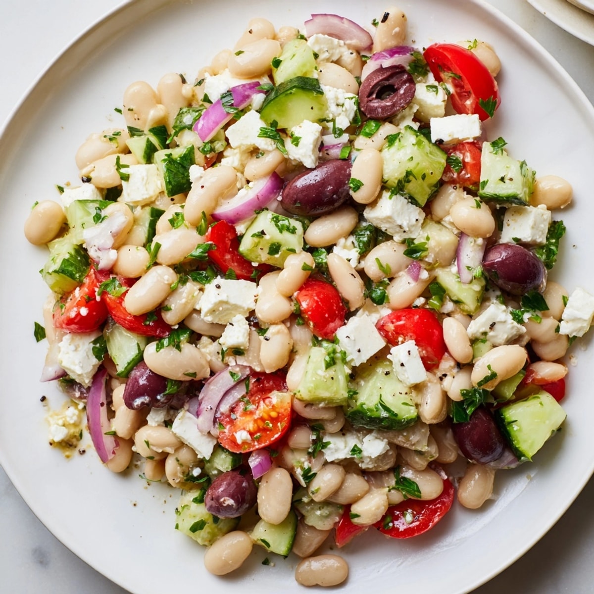 Tangy Mediterranean White Bean Salad with Feta, a colorful and refreshing dish.