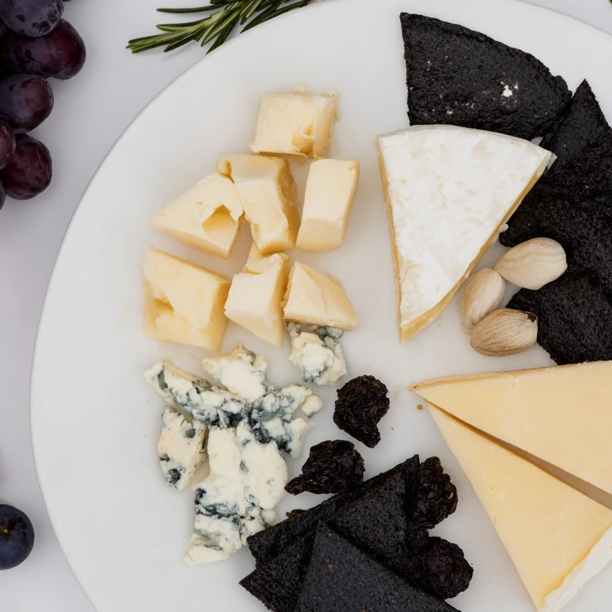 A starry Crescent Moon & Stars Cheese Board featuring gouda stars, creamy brie, and dark black crackers for a party.