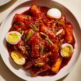A close-up of Korean tteokbokki showcasing the chewy rice cakes and tender, boiled eggs.