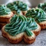 Buttery sugar cookies shaped like shamrocks and topped with smooth royal icing, ideal for sharing on St. Patrick's Day.  