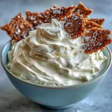 Creamy, fluffy cheesecake dip with powdered sugar and whipped cream, served chilled alongside honey graham crackers for a sweet treat.  