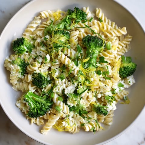 Steaming hot Green Goddess Broccoli Cheddar One-Pot Pasta with cheese and broccoli visible.