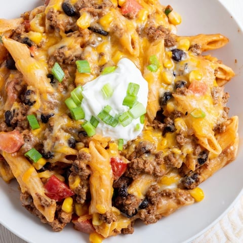 A bubbling skillet of Cheesy Taco Pasta, filled with creamy cheese and savory ground beef.