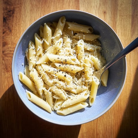 A single serving of Microwave Bowl Pasta, steaming with marinara sauce and a sprinkle of Parmesan, showcasing the easy microwave cooking method.  