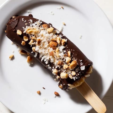 Homemade Frozen Banana Chocolate Pops with a peanut butter center, drizzled with chocolate.