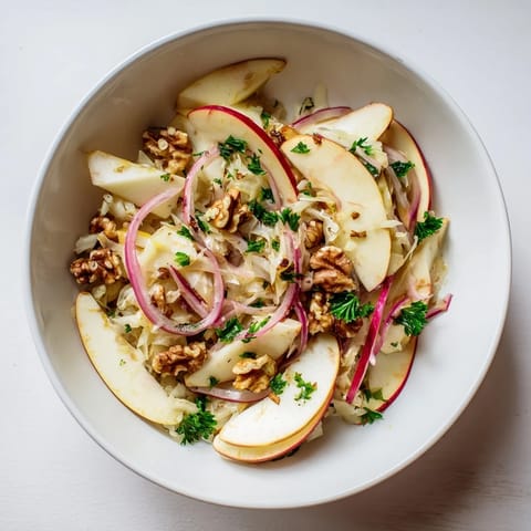 Savory Warm Apple and Sauerkraut Skillet Salad garnished with fresh parsley and toasted walnuts, ready to serve.  