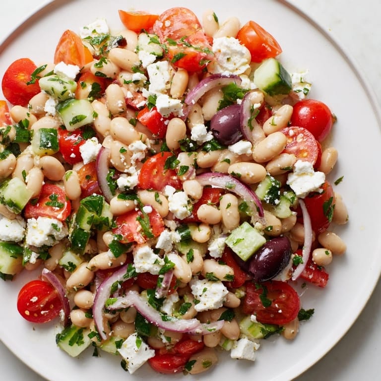 Close-up of Mediterranean White Bean Salad displaying feta, tomatoes and herbs.
