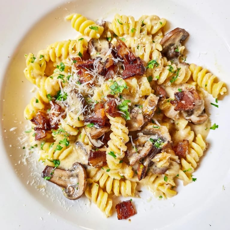 Flavorful fusilli with bacon, onions, and mushrooms; imagine the aroma and delicious, creamy sauce.
