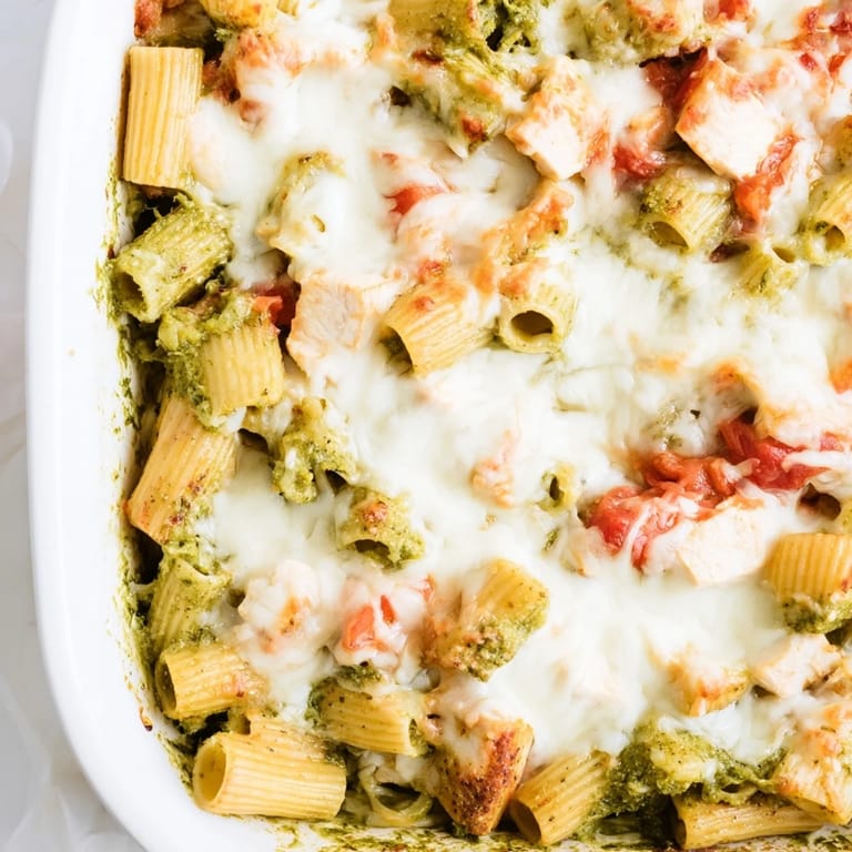 Serve this easy Pesto Chicken Pasta Bake from a ceramic dish, perfect for a comforting weeknight meal or potluck.