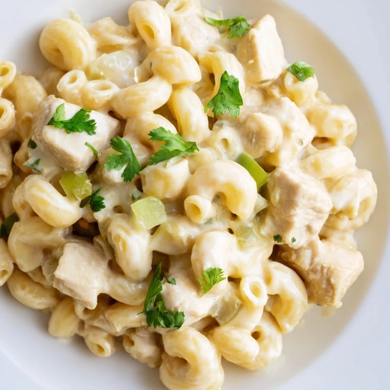 Bowl of Green Chili Chicken Mac with diced chicken, green chiles, and shredded Monterey Jack and cheddar cheese.