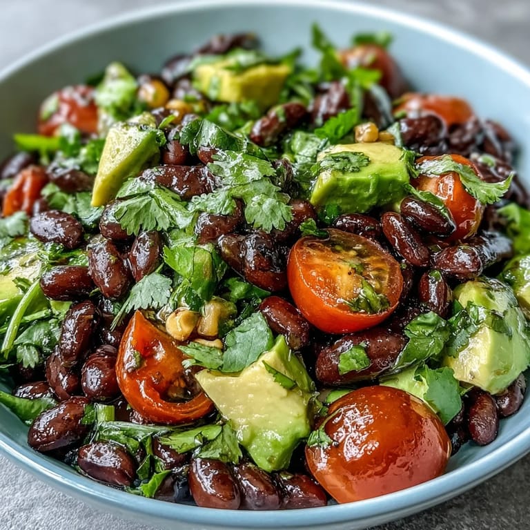 Overhead view of a fresh Black Bean and Veggie Bowl topped with cilantro and pumpkin seeds, ready to serve.